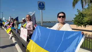 Люди з українськими прапорами зібралися на мосту неподалік резиденції Трампа, щ...
