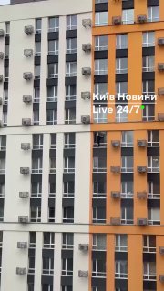 Під час тривог жінка миє вікно на верхніх поверхах...